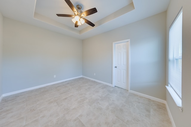 unfurnished room with a raised ceiling and ceiling fan