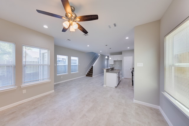 unfurnished living room featuring ceiling fan