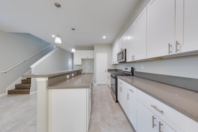 kitchen featuring sink, stainless steel appliances, hanging light fixtures, white cabinets, and an island with sink