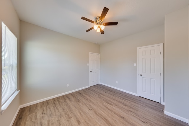 empty room with ceiling fan and light hardwood / wood-style flooring