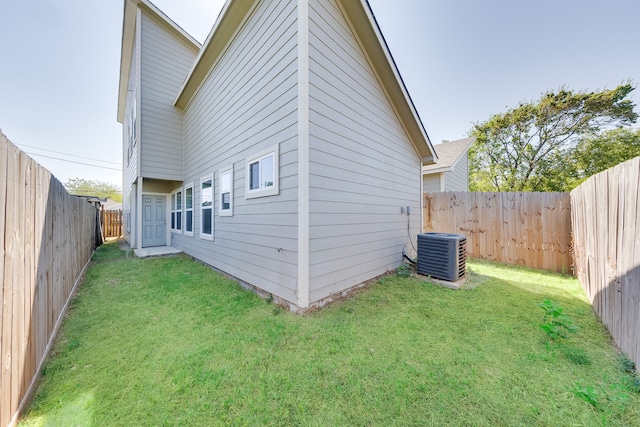 back of property featuring central air condition unit and a lawn