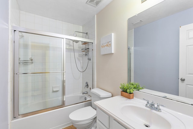 full bathroom featuring shower / bath combination with glass door, vanity, and toilet