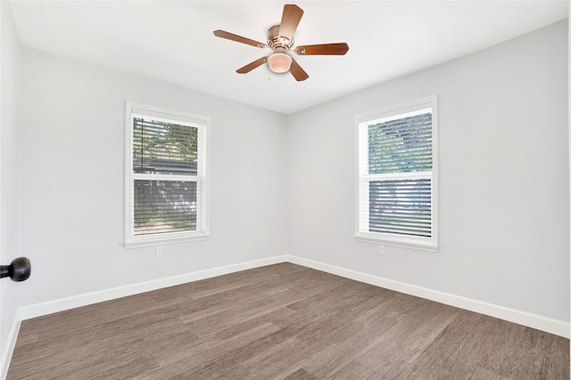 spare room featuring ceiling fan, dark wood-type flooring, and a wealth of natural light