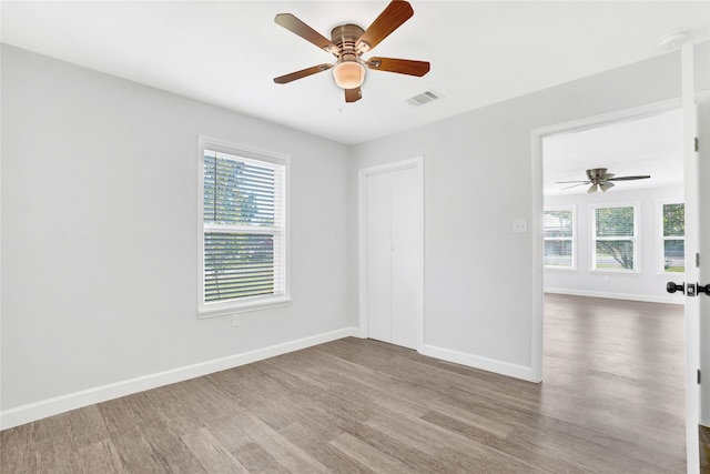 unfurnished room with plenty of natural light, hardwood / wood-style floors, and ceiling fan