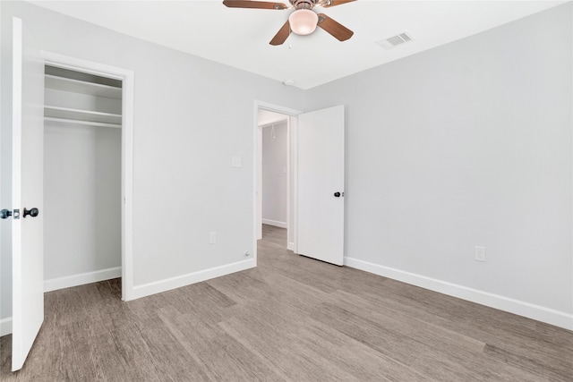 unfurnished bedroom featuring ceiling fan, a closet, and light hardwood / wood-style flooring