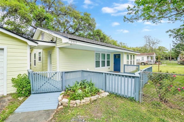 exterior space with a wooden deck and a front lawn