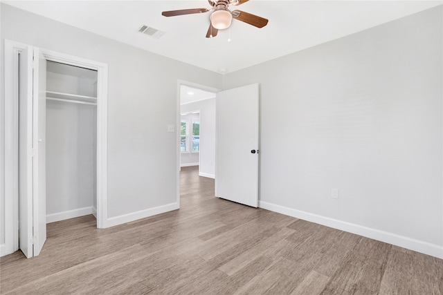 unfurnished bedroom featuring ceiling fan, a closet, and light hardwood / wood-style floors