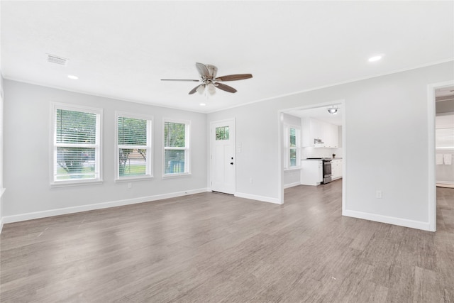 unfurnished living room with ceiling fan, plenty of natural light, and light hardwood / wood-style flooring