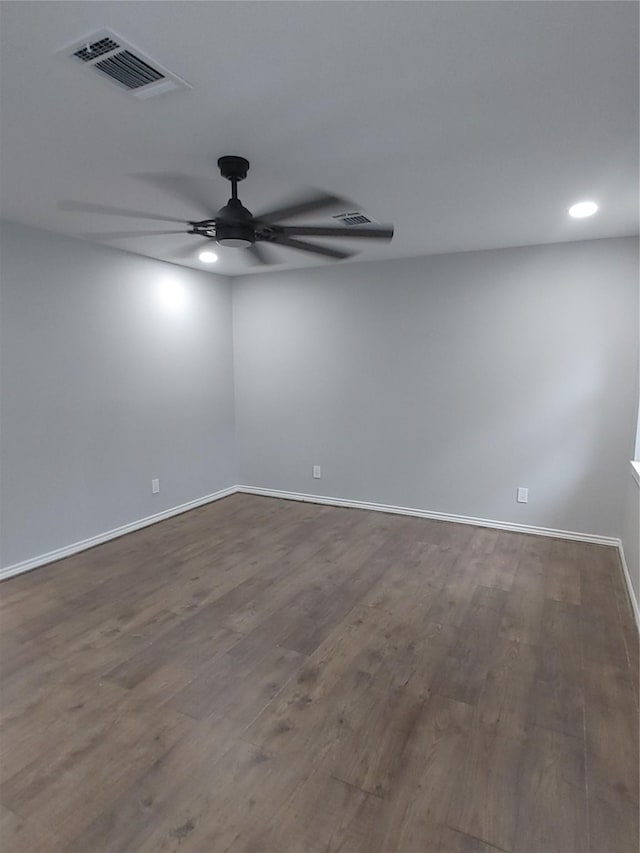 empty room featuring baseboards, ceiling fan, visible vents, and wood finished floors