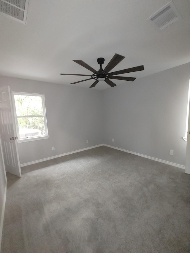 unfurnished room featuring carpet flooring, visible vents, and baseboards