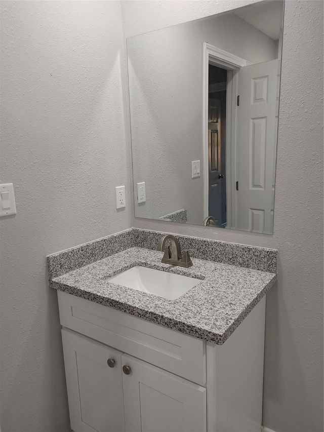 bathroom featuring a textured wall and vanity