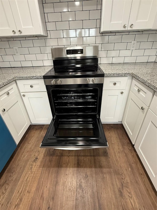 kitchen with white cabinetry, dark wood finished floors, light stone counters, and stainless steel range with electric cooktop