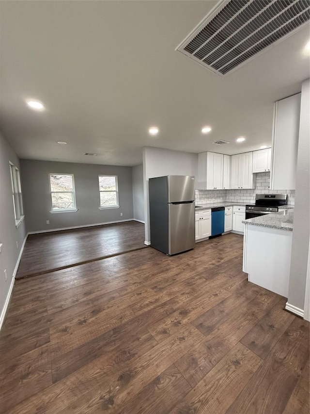 kitchen featuring visible vents, white cabinets, open floor plan, stainless steel appliances, and backsplash