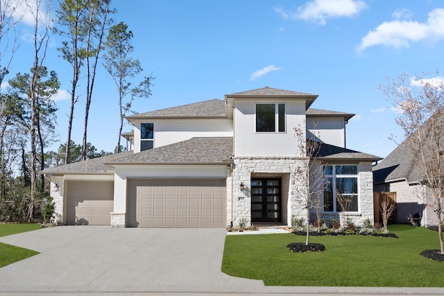 prairie-style home featuring a front lawn, a garage, and french doors