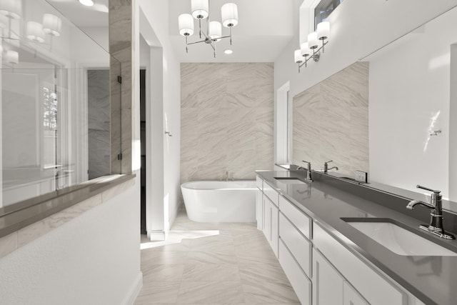 bathroom featuring tile walls, vanity, a chandelier, and separate shower and tub