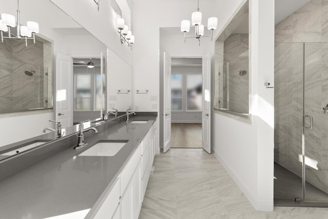 bathroom with ceiling fan with notable chandelier, a shower with door, and vanity