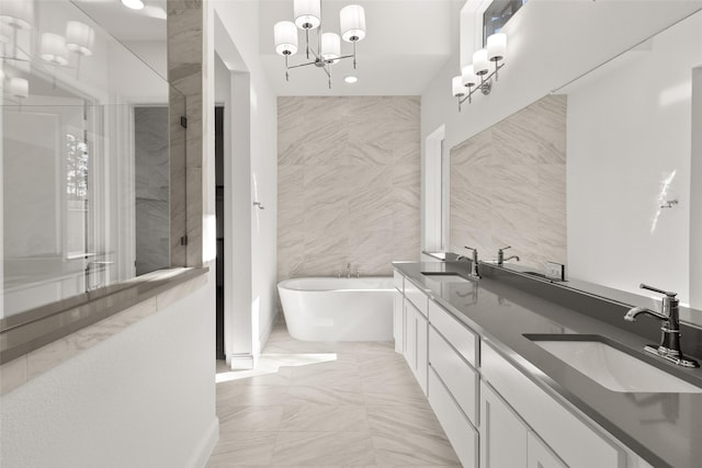 bathroom with vanity, tile walls, a notable chandelier, and plus walk in shower