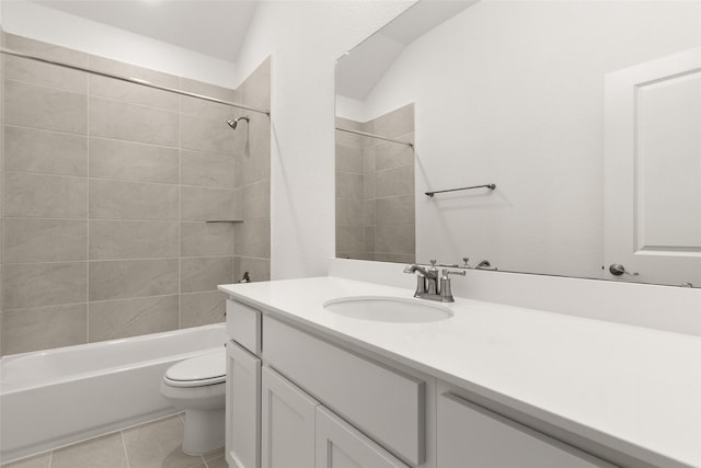 full bathroom featuring toilet, tiled shower / bath, lofted ceiling, tile patterned floors, and vanity