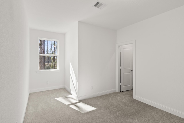 unfurnished room featuring light colored carpet, visible vents, and baseboards