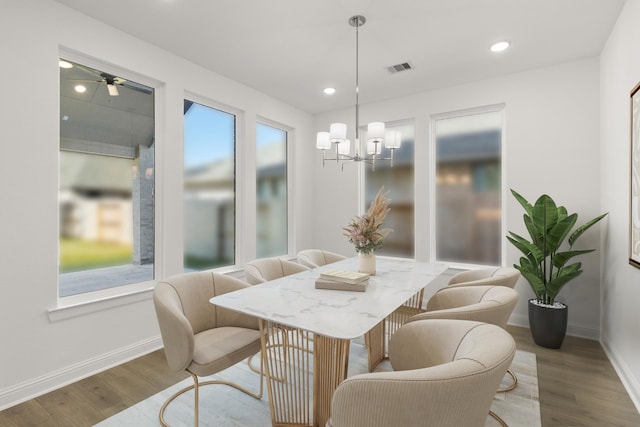 dining space featuring a chandelier, wood finished floors, and baseboards