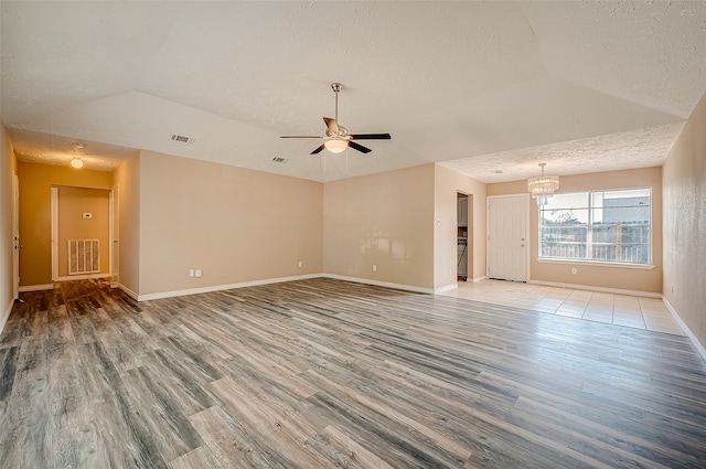 unfurnished room featuring a textured ceiling, light hardwood / wood-style flooring, ceiling fan, and lofted ceiling