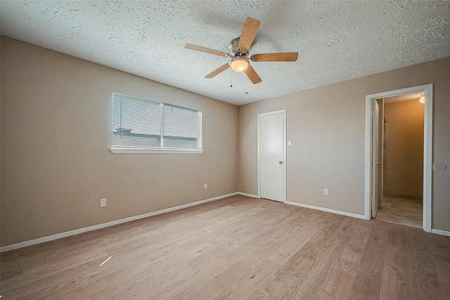 unfurnished bedroom featuring ceiling fan, light wood-type flooring, and a textured ceiling