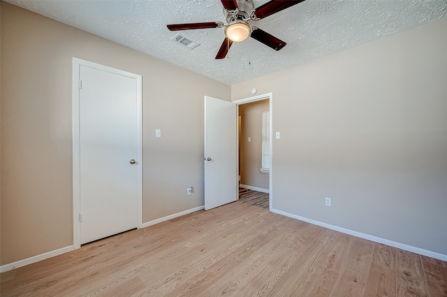 unfurnished bedroom featuring a textured ceiling, light hardwood / wood-style flooring, and ceiling fan