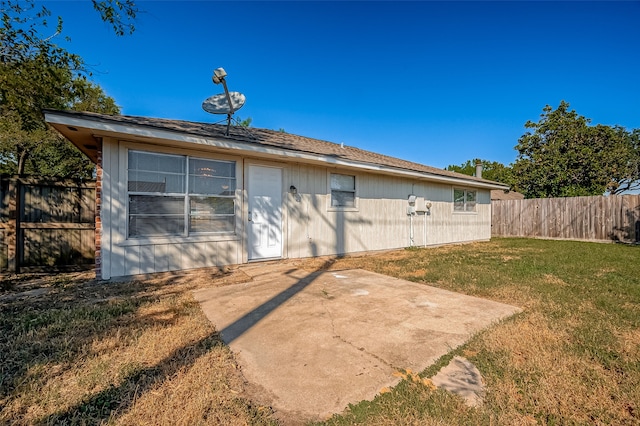 rear view of property featuring a lawn and a patio