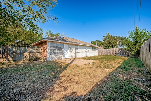 rear view of property featuring a lawn