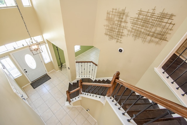 foyer entrance featuring a towering ceiling and light tile patterned flooring