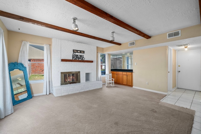 unfurnished living room with a textured ceiling, plenty of natural light, and beam ceiling