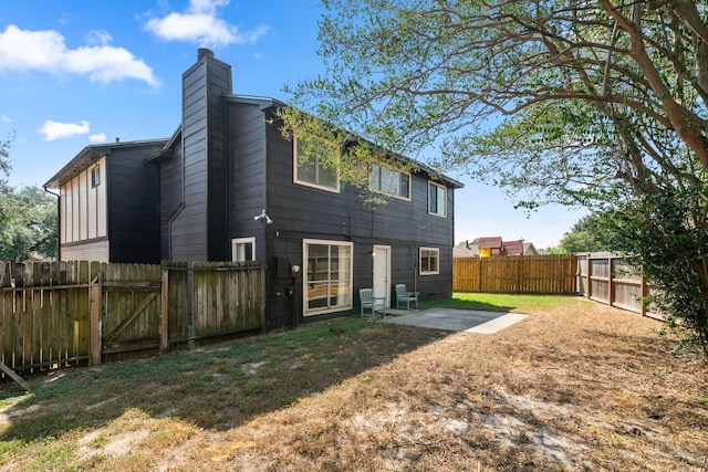 back of house with a yard and a patio area