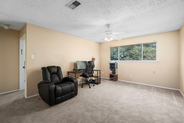 office area with light colored carpet, a textured ceiling, and ceiling fan