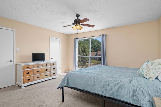 bedroom with ceiling fan, carpet floors, and a textured ceiling