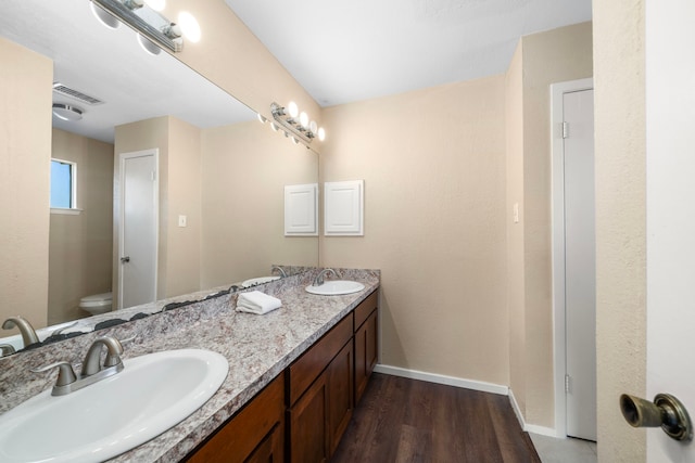 bathroom featuring vanity, toilet, and wood-type flooring