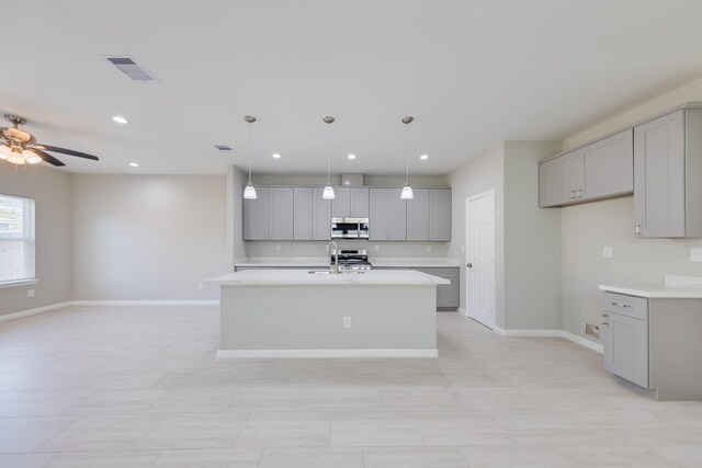 309A De Haven St, Houston, TX 77029 - kitchen with stainless steel microwave, gray cabinetry, and visible vents