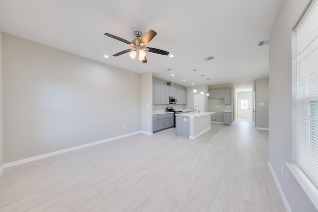 unfurnished living room with sink and ceiling fan