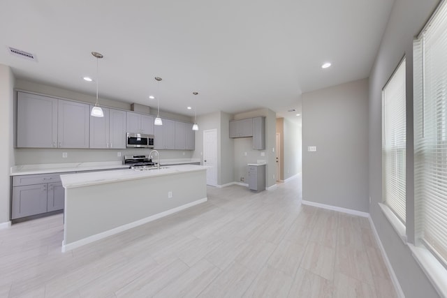 309A De Haven St, Houston, TX 77029 - kitchen with stove, stainless steel microwave, gray cabinetry, and visible vents