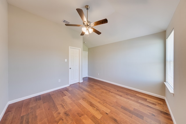 unfurnished room with ceiling fan, vaulted ceiling, plenty of natural light, and hardwood / wood-style floors