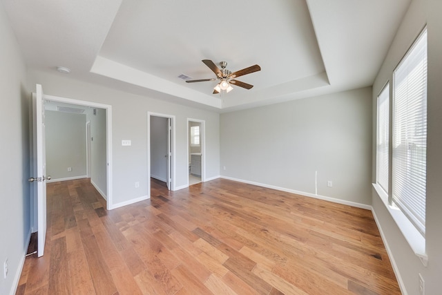 309A De Haven St, Houston, TX 77029 - unfurnished room featuring baseboards, light wood-style flooring, visible vents, a tray ceiling, and ceiling fan