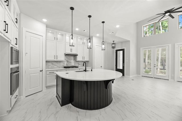 kitchen featuring white cabinets, tasteful backsplash, appliances with stainless steel finishes, french doors, and decorative light fixtures