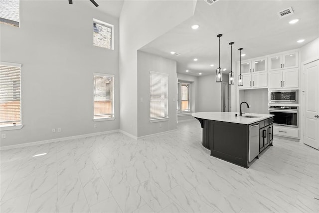 kitchen featuring a center island with sink, appliances with stainless steel finishes, white cabinetry, plenty of natural light, and sink