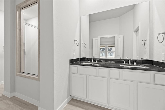 bathroom featuring vanity, hardwood / wood-style flooring, and a shower with door