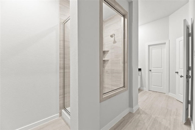 bathroom with an enclosed shower and hardwood / wood-style flooring