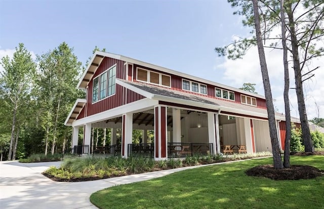 rear view of property featuring a yard, ceiling fan, and a porch