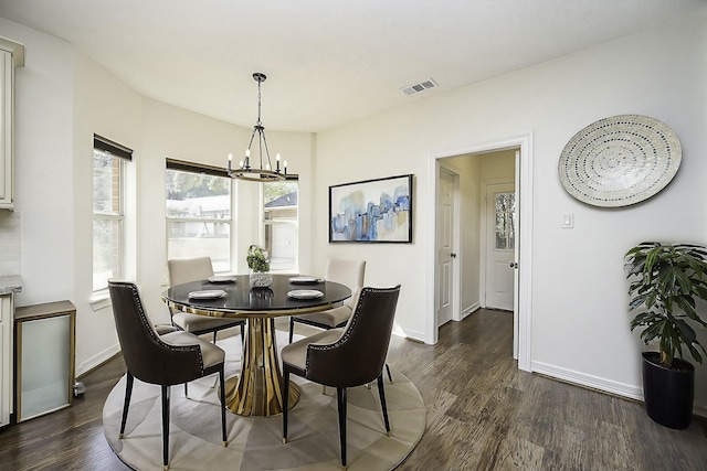 dining room with an inviting chandelier and dark wood-type flooring