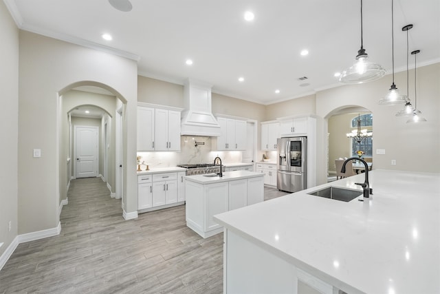 kitchen with stainless steel appliances, white cabinets, decorative light fixtures, and sink