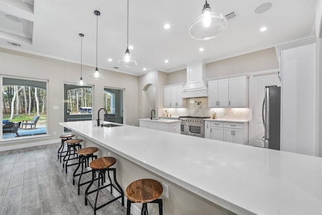 kitchen featuring appliances with stainless steel finishes, decorative light fixtures, sink, and white cabinets