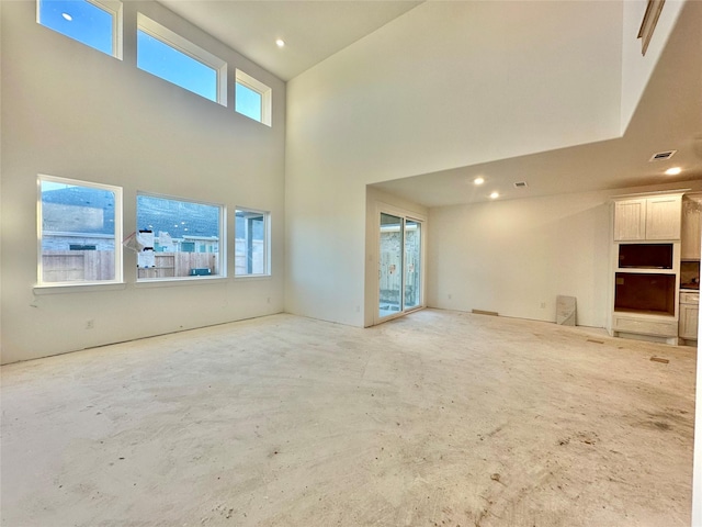 unfurnished living room featuring a high ceiling