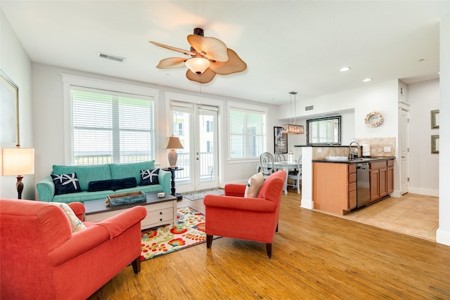 living room with ceiling fan, sink, and light hardwood / wood-style floors